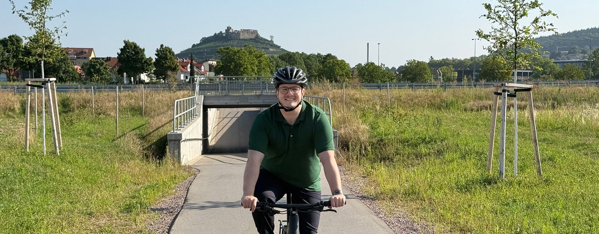 Gilbert Weber auf dem Fahrrad. Im Hintergrund die Burgruine von Staufen im Breisgau